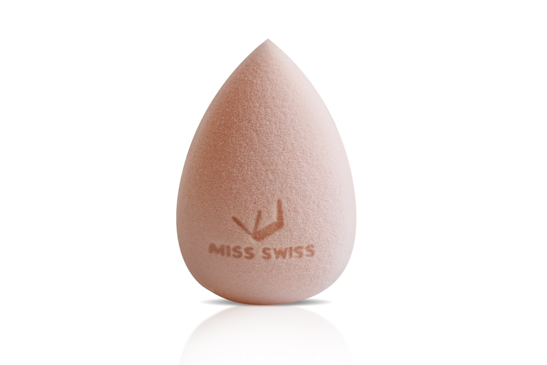 A peach teardrop-shaped makeup sponge on a white background