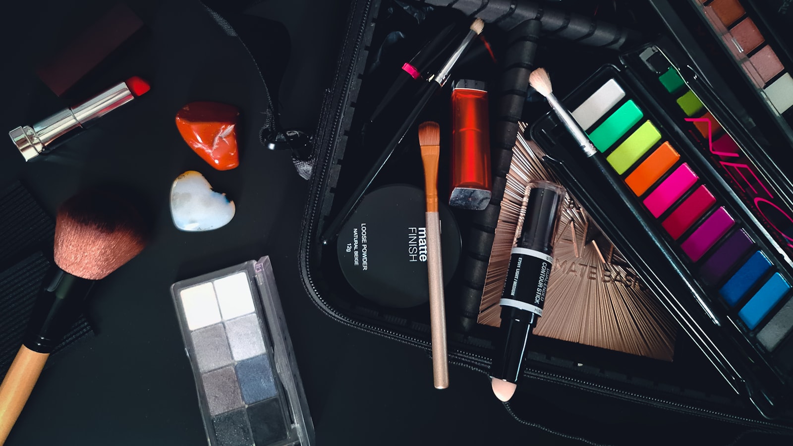 A makeup bag is open with various makeup products and brushes inside